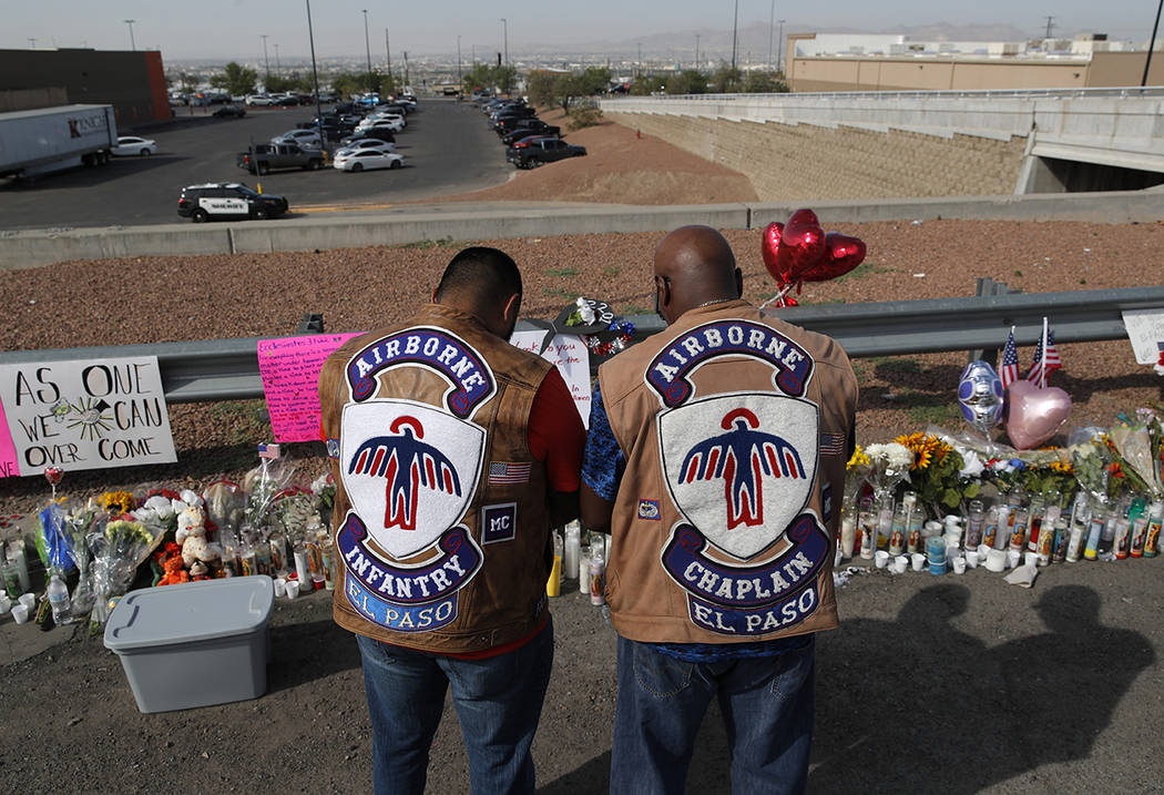 People pray a makeshift memorial for victims of a mass shooting at a shopping complex Monday, A ...