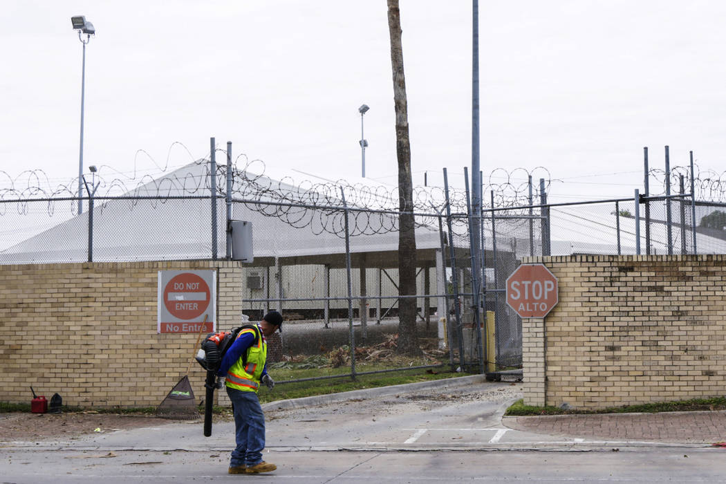 A man uses a leaf blower to clean the sidewalk Thursday, July 25, 2019, outside tent facilities ...