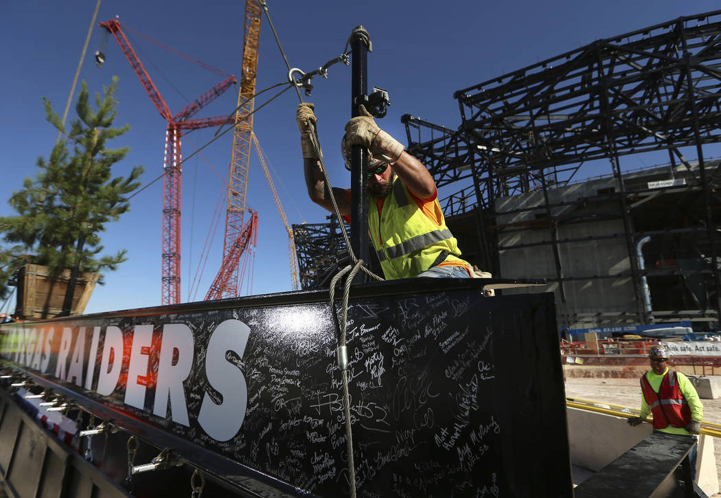 Zac Carter, iron worker with Local 597, secures a steel beam during the Allegiant Stadium Toppi ...