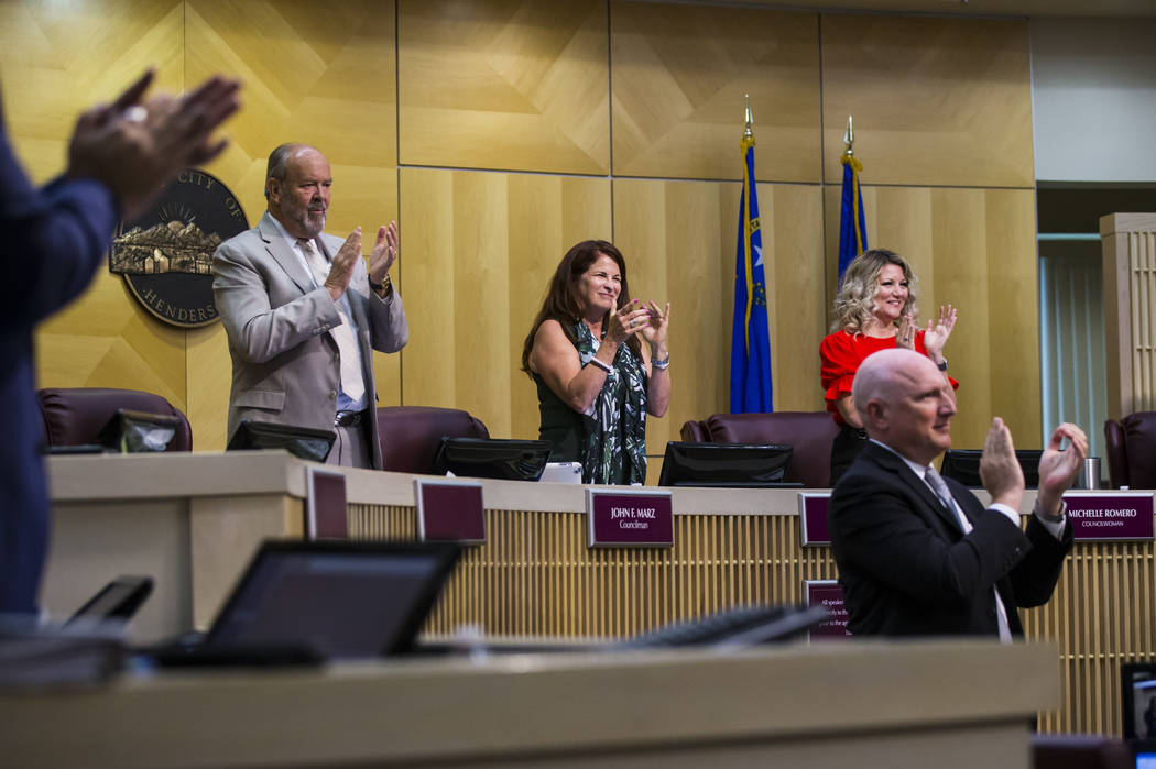 Henderson Mayor Debra March, center, claps alongside councilman John Marz, left, and councilwom ...