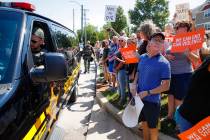 Demonstrators gather while authorities keep them across the street during their protest against ...