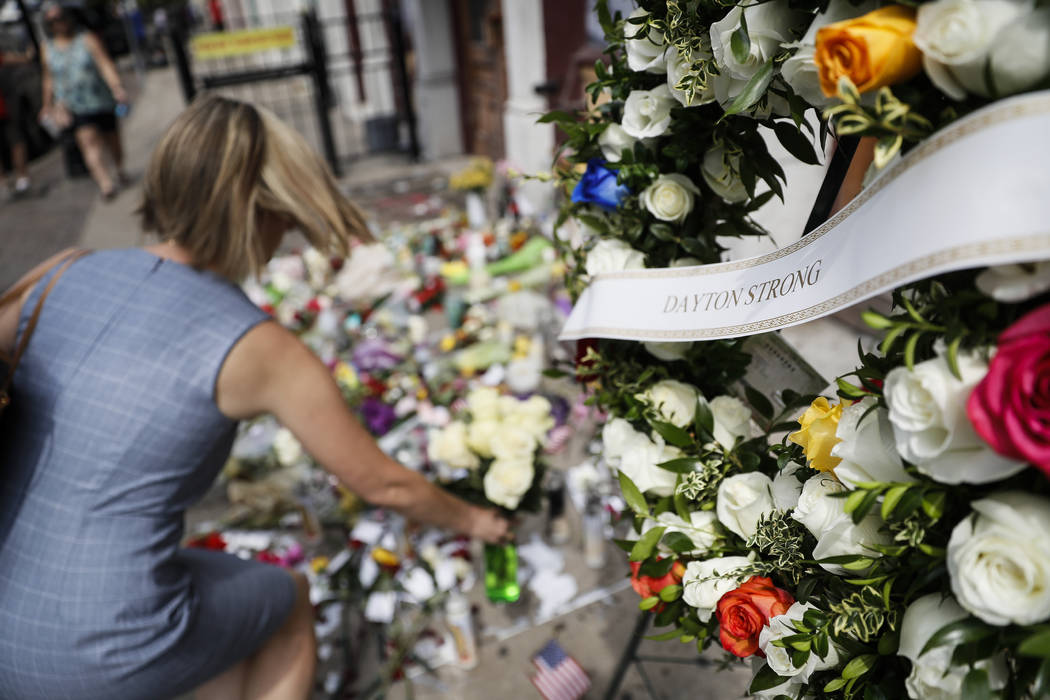 Mourners bring flowers to a makeshift memorial Tuesday, Aug. 6, 2019, for the slain and injured ...