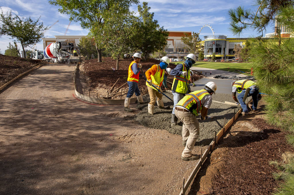 Construction crew lay a concrete path at Wynn Golf Club on Tuesday, July 30, 2019, in Las Vegas ...