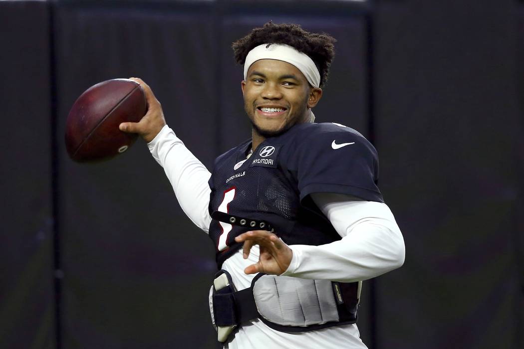 Arizona Cardinals quarterback Kyler Murray smiles as he throws a pass during an NFL football tr ...