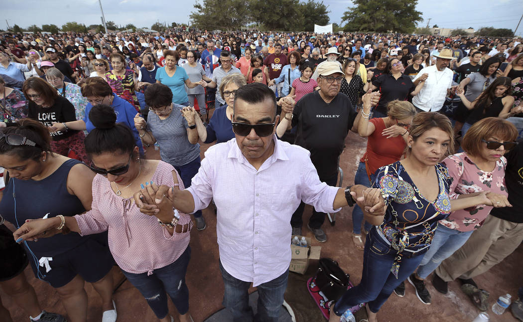 In this Aug. 4, 2019, file photo, people join hands and pray during the Hope Border Institute p ...