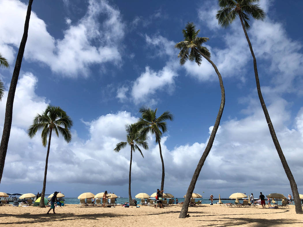 Beach umbrellas are shown on Waikiki Beach in front of the Hilton Hawaiian Village in Honolulu ...