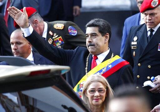 Venezuela's President Nicolas Maduro, accompanied by first lady Cilia Flores, waves to supporte ...