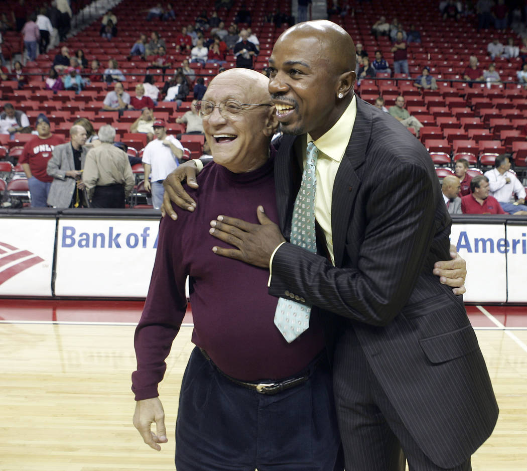 Former UNLV head basketball coach Jerry Tarkanian, left, gets a hug from former Rebel player an ...
