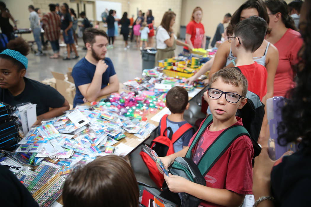 Eight-year-old Sebastian Stockmann, right, selects free school supplies during an event for mil ...