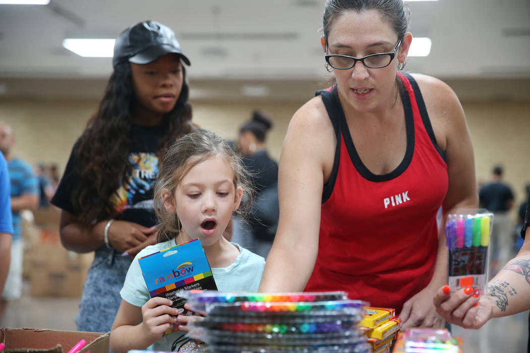 Danielle Dejarnette, right, with her daughter Aria, 6, select free school supplies during an ev ...