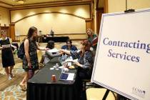 Ashley Robins, left, and Catherine McDonnell stand in line at Contracting Services desk during ...