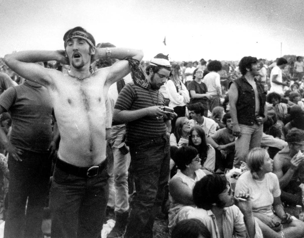 Rock music fans relax during a break in the entertainment at the Woodstock Music and Arts Fair ...