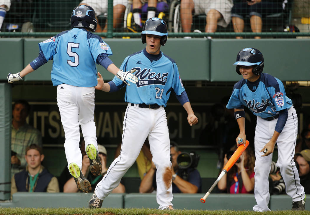 Las Vegas' Justin Hausner (5) leaps on home plate and celebrates with teammates Austin Kryszczu ...