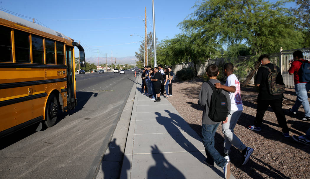 Sunrise Mountain High School students prepare to board the school bus at East Owens Avenue and ...