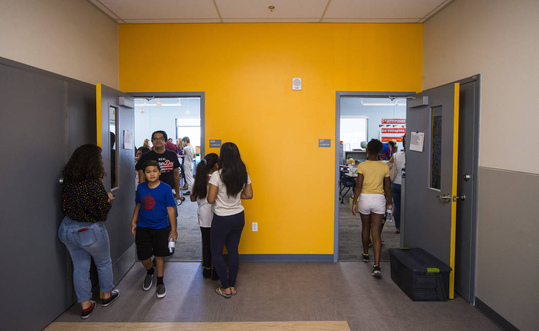 Students and parents explore classrooms after a ribbon-cutting ceremony for Earl Jenkins Elemen ...