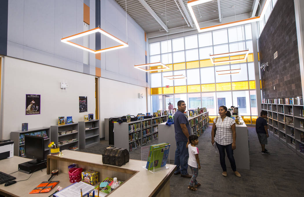 A family checks out the library after the ribbon-cutting ceremony for Earl Jenkins Elementary S ...