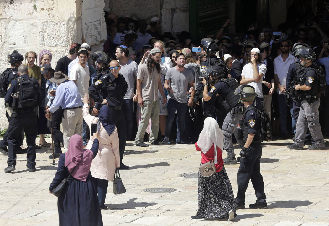 Palestinian women confornt Jewish worshippers as the enter al-Aqsa mosque compound in Jerusalem ...