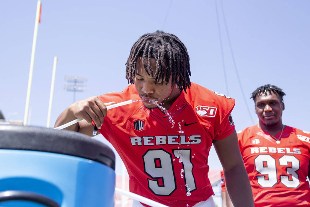 UNLV's defensive line Nate Neal (91) hydrates during the team's photo day at Sam Boyd Stadium i ...