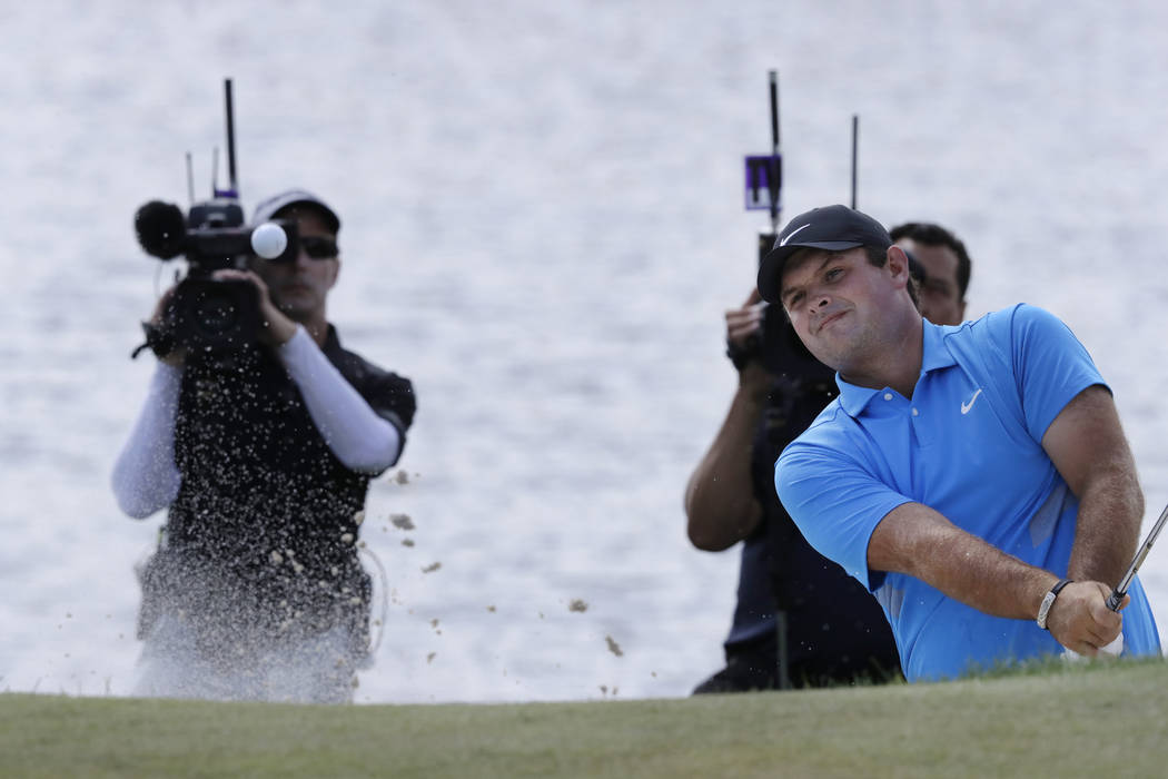 Patrick Reed hits out of a bunker on the fourth hole in the final round of the Northern Trust g ...