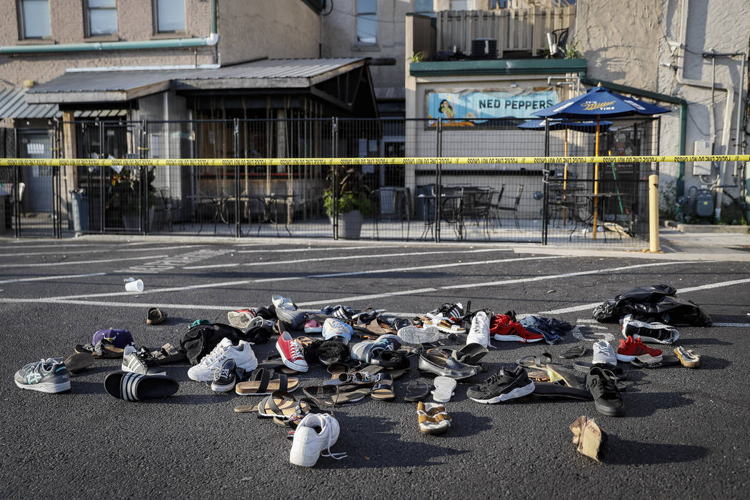 Shoes are piled outside the scene of a mass shooting including Ned Peppers bar, Sunday, Aug. 4, ...