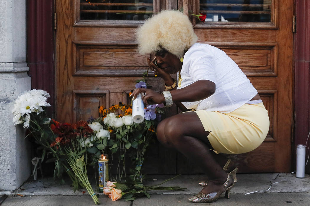 Annette Gibson Strong places candles at a makeshift memorial for the slain and wounded at the s ...