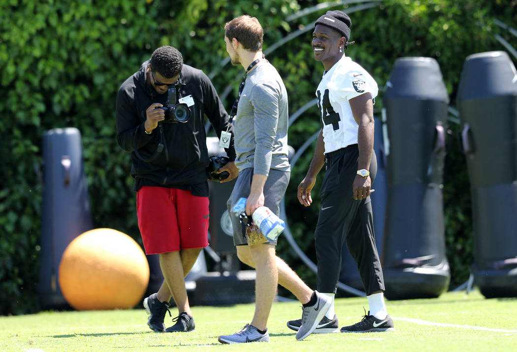 Oakland Raiders wide receiver Antonio Brown (84), right, walks on the field during the NFL team ...