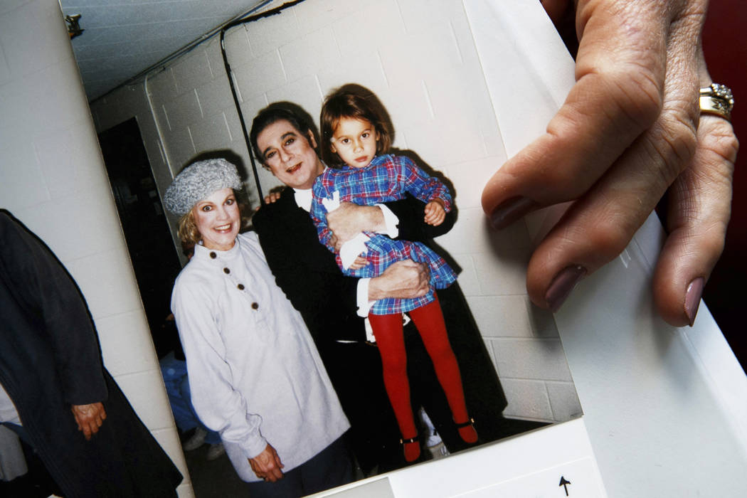 Opera singer Patricia Wulf holds a 1998 photo of herself, left, with opera star Placido Domingo ...