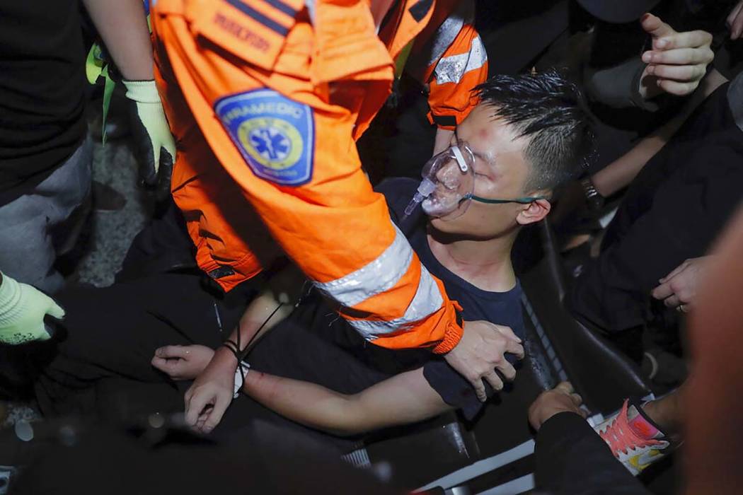 A medical staffer helps a detained man, who protesters claimed was a police officer from mainla ...