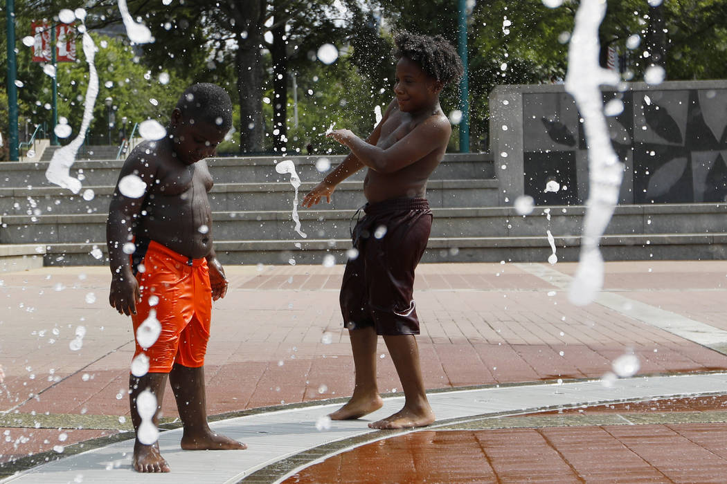 Kai Frazier and Chance Seawright, brothers visiting from Aiken, South Carolina, cool off while ...