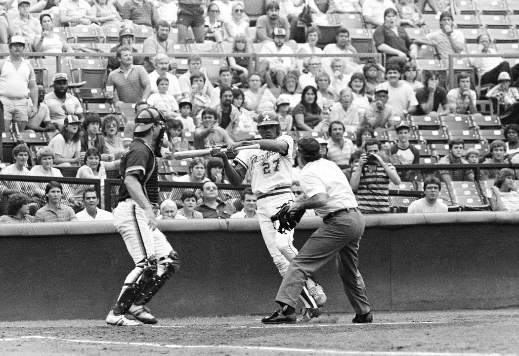 Home Plate umpire Steve Rippley blocks bat-swinging Atlanta Braves Pascual Perez in the second ...