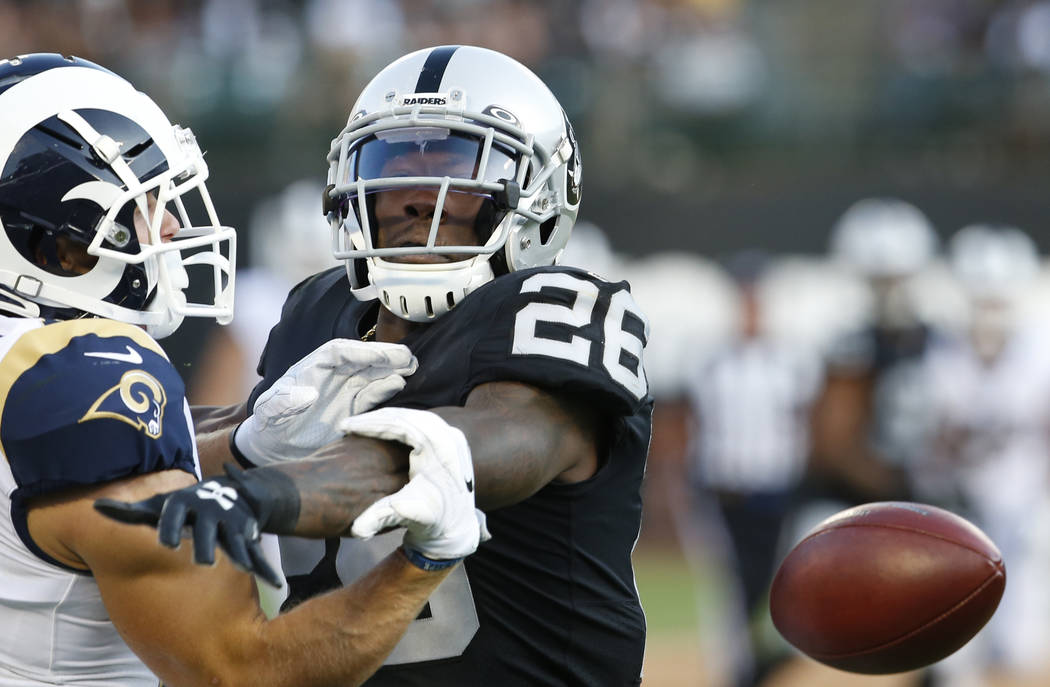 Oakland Raiders' Nevin Lawson, right, breaks up a pass intended for Los Angeles Rams' Alex Bach ...