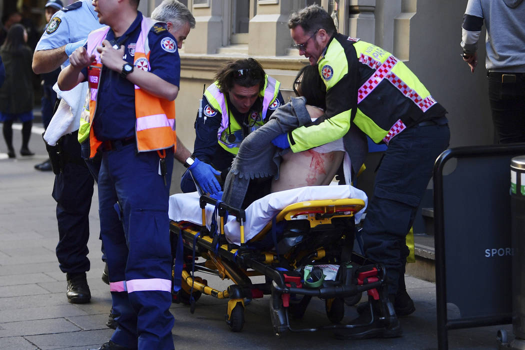 An injured woman is taken by ambulance from Hotel CBD at the corner of King and York Street in ...