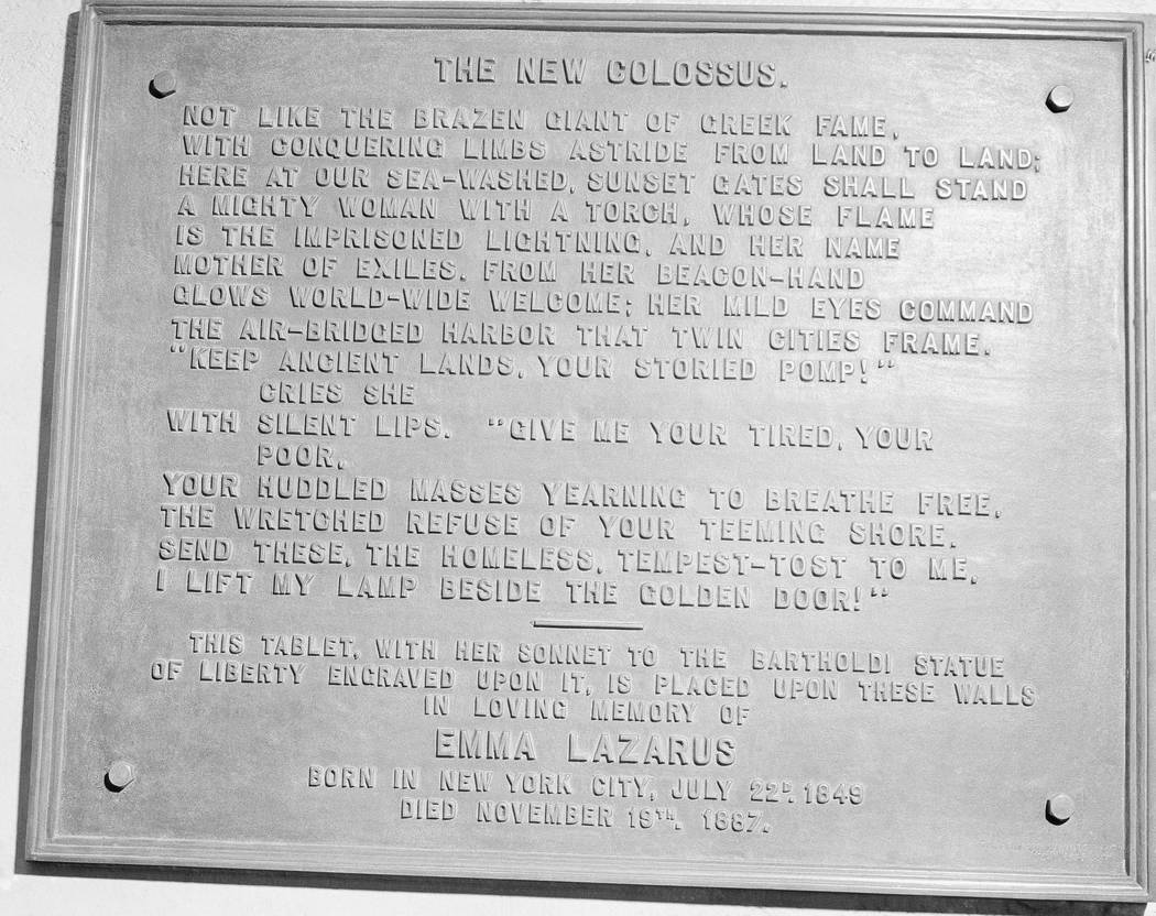 FILE- In this circa 1950 photo shows a bronze plaque of the poem by Poet Emma Lazurus on Statue ...