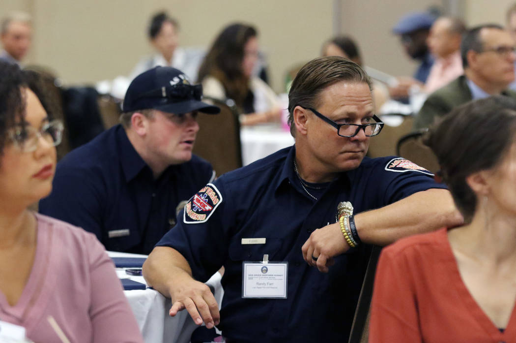 Randy Farr, second right, and Brandon Sorensen, second left, of Las Vegas Fire and Rescue atten ...