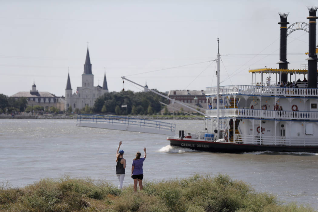 In this July 25, 2019, photo, Roxanne Taylor, right, and Brigitte Blanchard, wave to a paddlewh ...