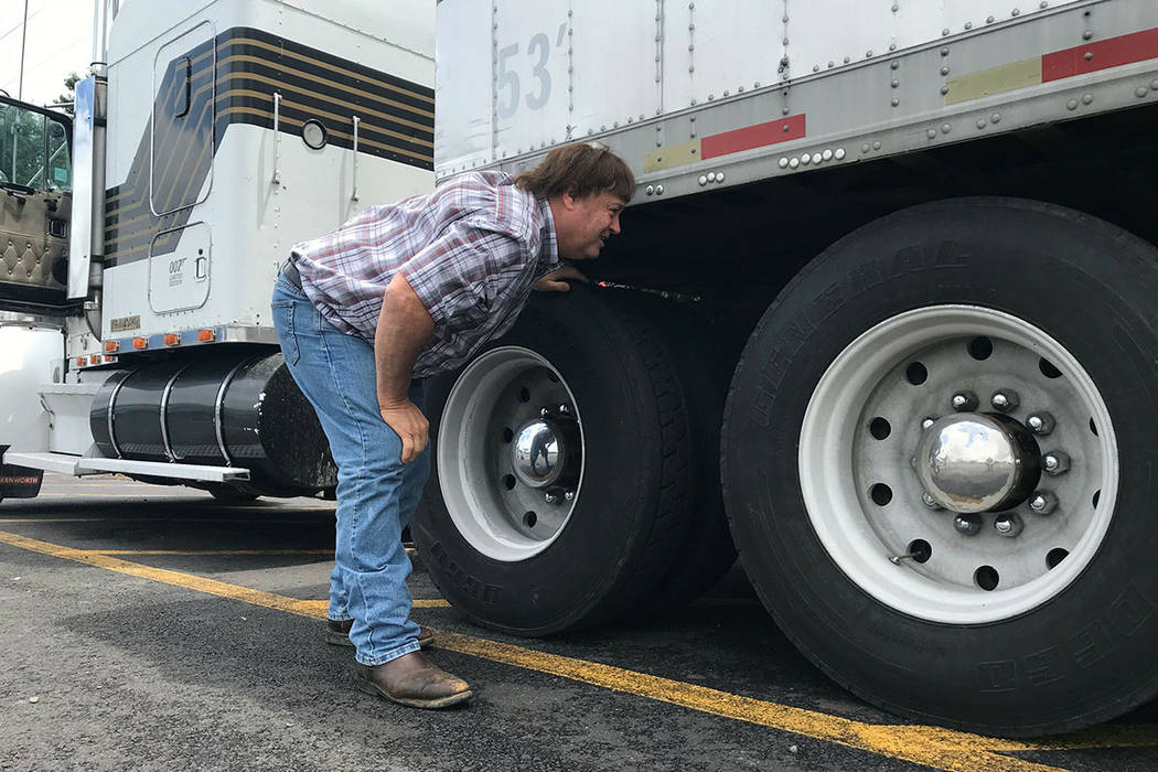 In this June 13, 2019 photo, truck driver Terry Button looks over his trailer during at stop in ...