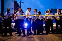 Officers gather for crowd control near a massive police presence set up outside a house as they ...