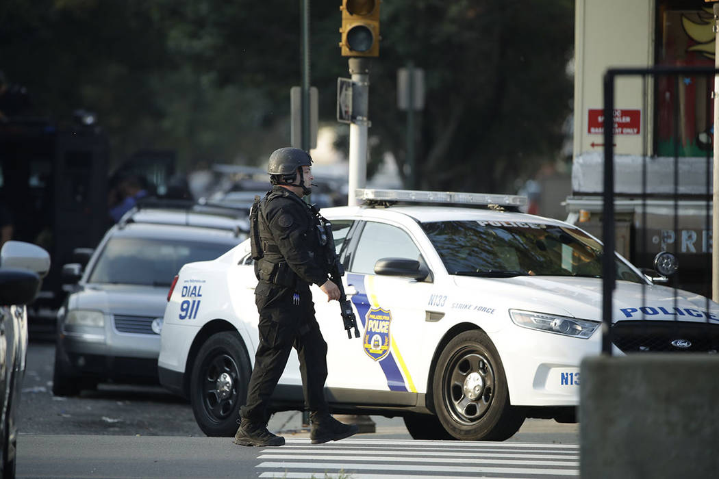 A police officer patrols the block near a house as they investigate an active shooting situatio ...