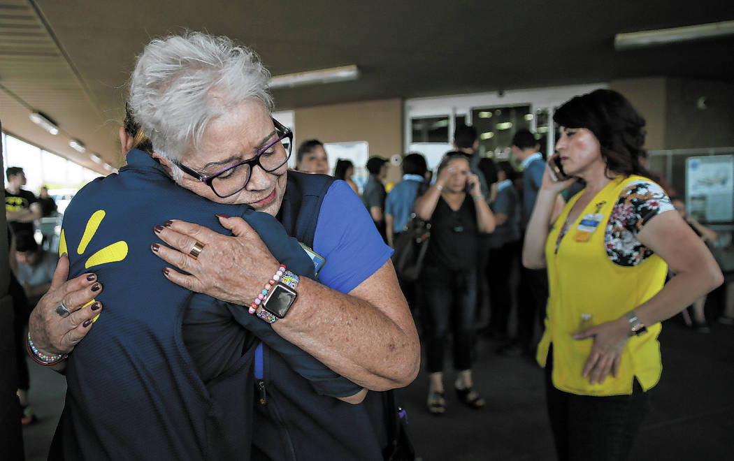 Walmart employees comfort one another after an active shooter opened fire at the store in El Pa ...