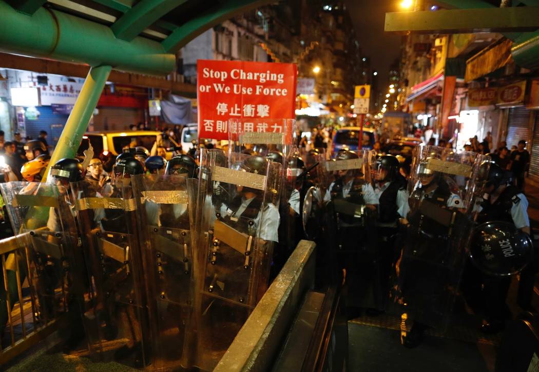 Police move out from the Shum Shui Po police station to confront protesters in Hong Kong on Wed ...