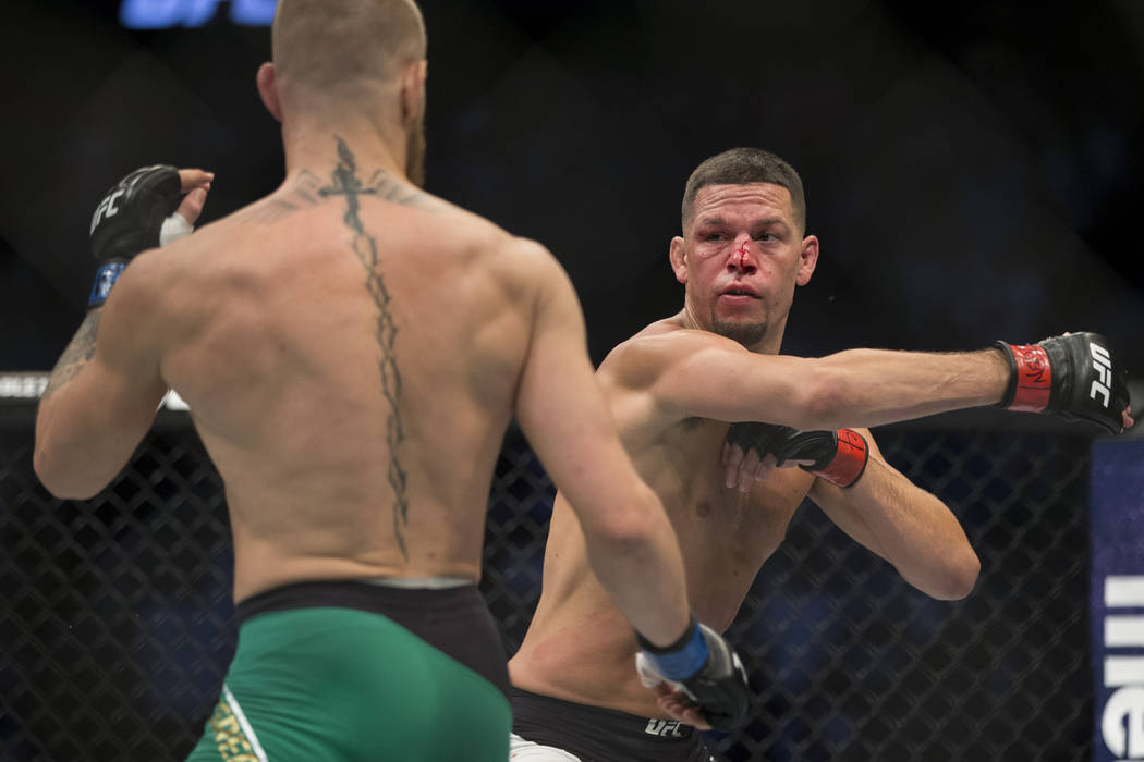 Conor McGregor, left, battles Nate Diaz in the welterweight bout during UFC 202 at T-Mobile Are ...