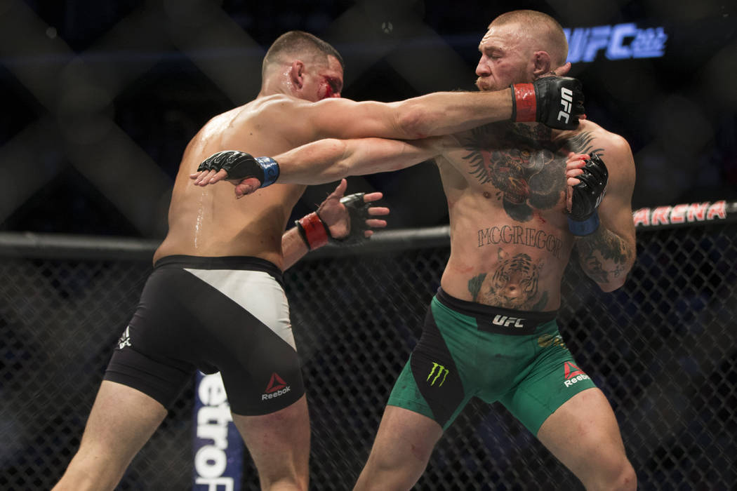 Nate Diaz, left, battles against Conor McGregor in the welterweight bout during UFC 202 at T-Mo ...