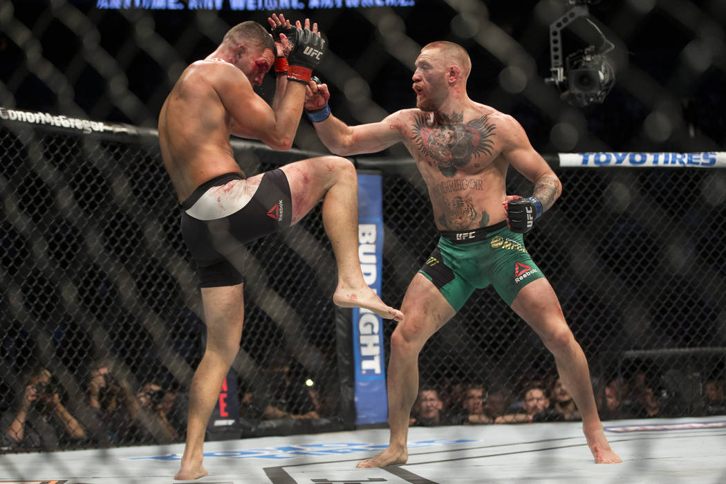 Nate Diaz, left, battles Conor McGregor in the welterweight bout during UFC 202 at T-Mobile Are ...