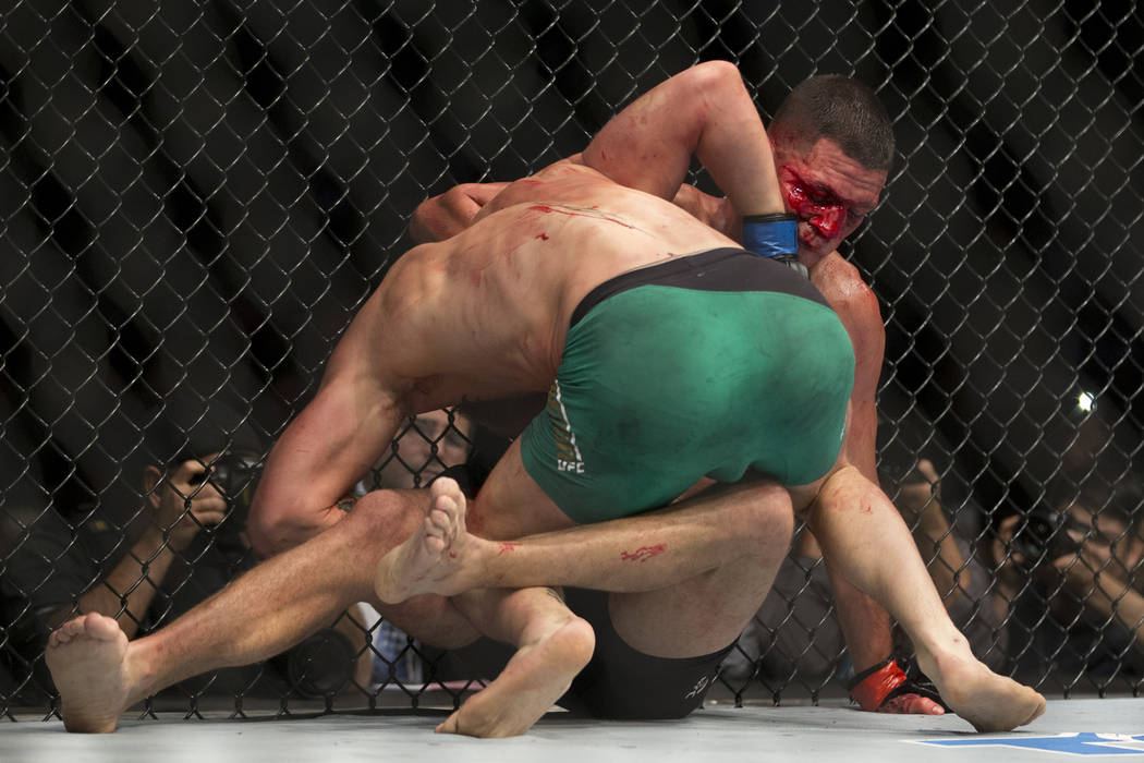 Conor McGregor, left, battles Nate Diaz in the welterweight bout during UFC 202 at T-Mobile Are ...