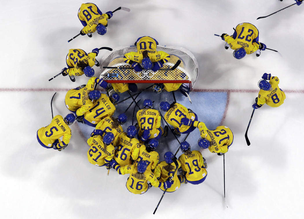 Players from Sweden gather before the preliminary round of the women's hockey game against the ...