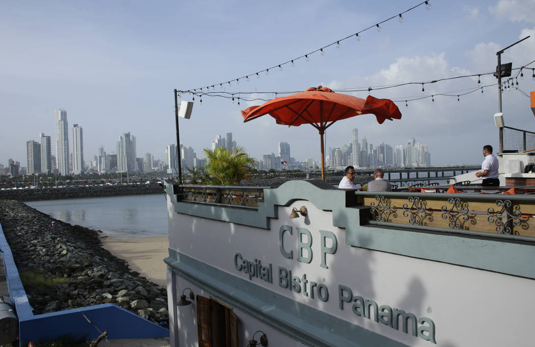 In this photo taken on Sunday, July 28, 2019, with Panama City's skyline on the background, men ...