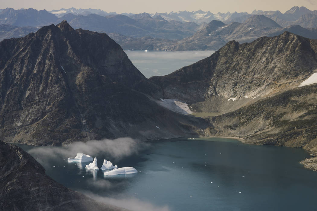 In this photo taken on Wednesday, Aug. 14, 2019, icebergs are photographed from the window of a ...