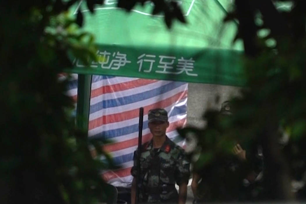 In this image made from video, a soldier stands guard near armed police vehicles parked outside ...