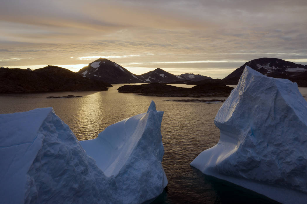 An aerial view of large Icebergs floating as the sun rises near Kulusuk, Greenland, early Frida ...