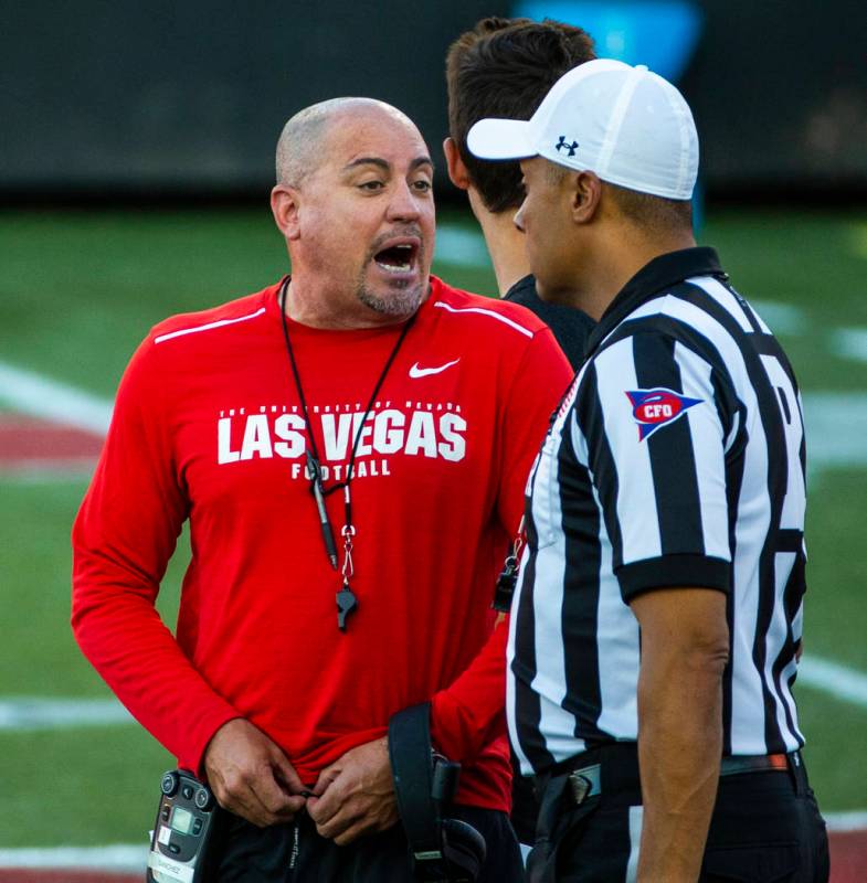 UNLV head coach Tony Sanchez talks with an official on the field during their first major scrim ...
